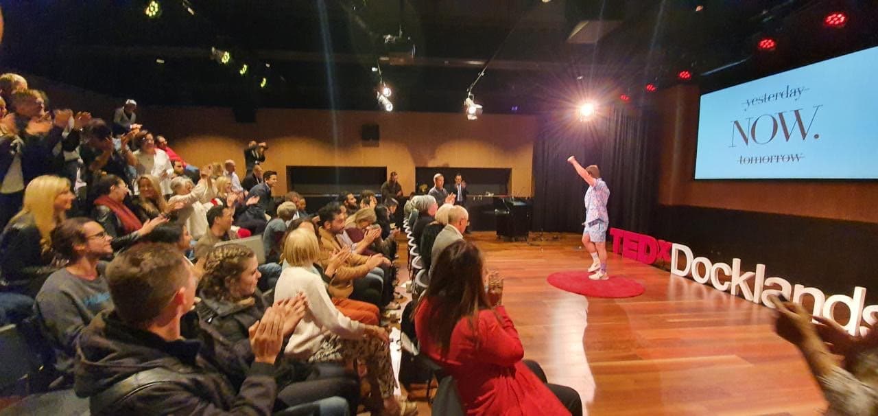 Dale Sidebottom on the TEDx Docklands red dot, speaking to a packed audience