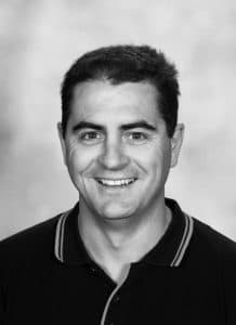 Simon Perry, black and white head and shoulders portrait, smiling