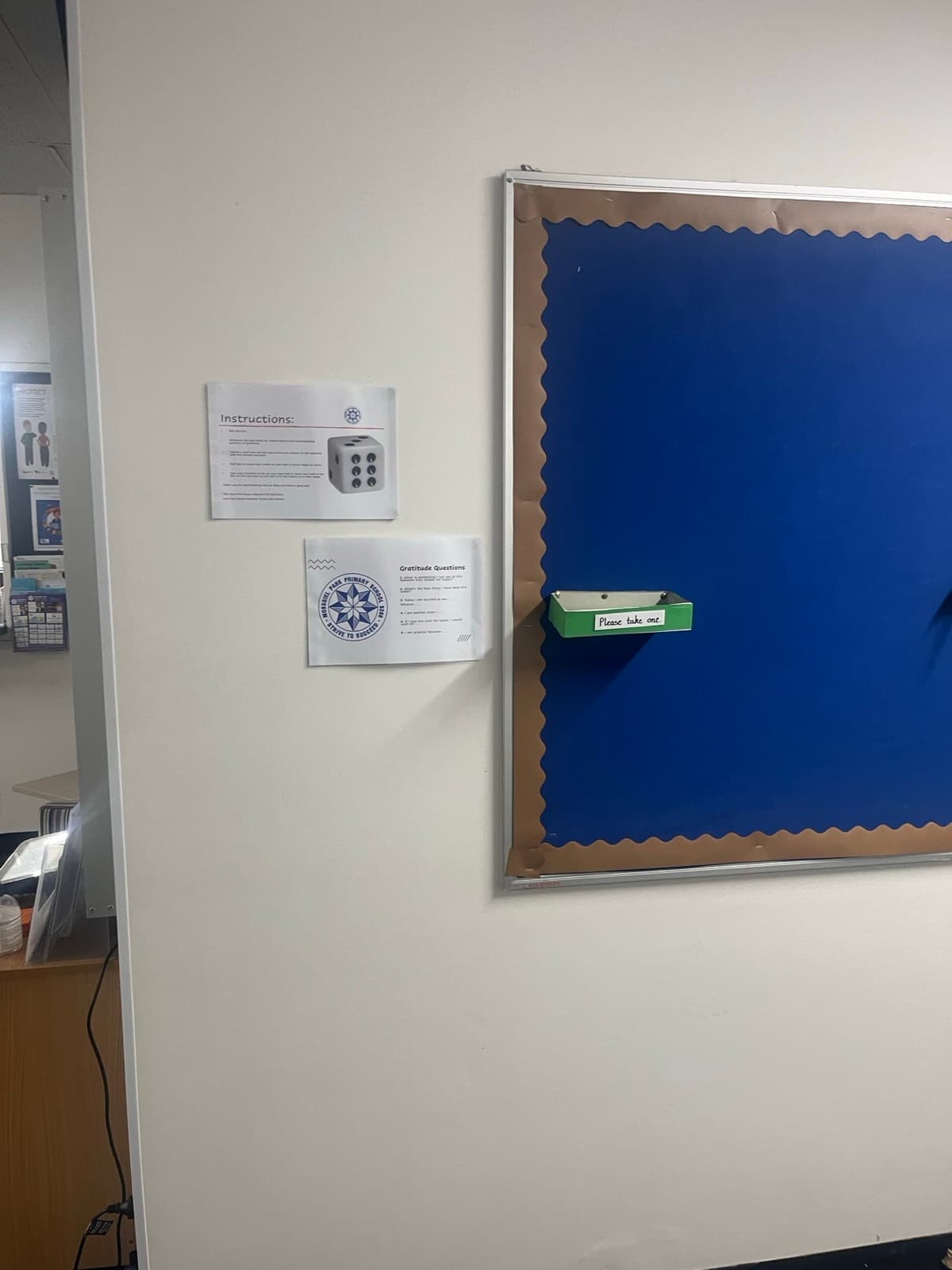 Gratitude question prompts and a take-one tray on a noticeboard at Mossgiel Park Primary